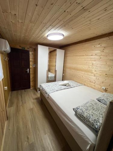 a bedroom with a large bed in a wooden room at Dori Cottage in Ada