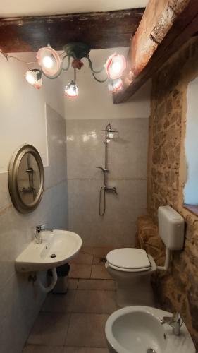 a bathroom with a toilet and a sink at Qui vive un sogno in Roccastrada