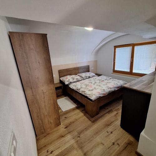 a bedroom with a bed and a wooden floor at CozyNest in Kamna Gorica