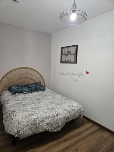 a bedroom with a bed and a picture on the wall at L Arcluzette in Fréterive