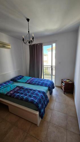 a bedroom with a bed and a large window at Villa Caesar in Ayia Napa