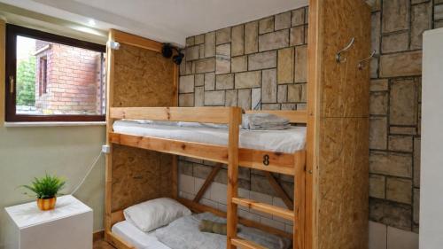 a bunk bed in a room with a brick wall at For rest Hostel in Lublin