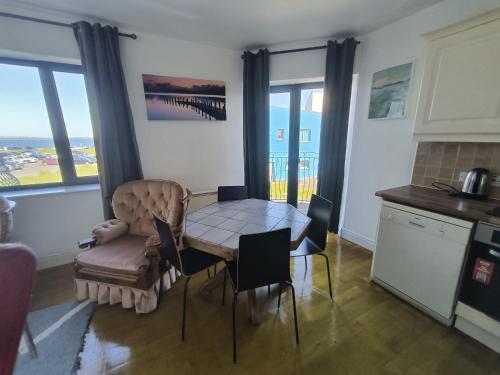 a dining room with a table and chairs and a kitchen at Bishops View in Galway