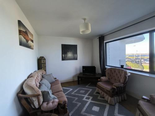 a living room with a couch and two chairs and a window at Bishops View in Galway