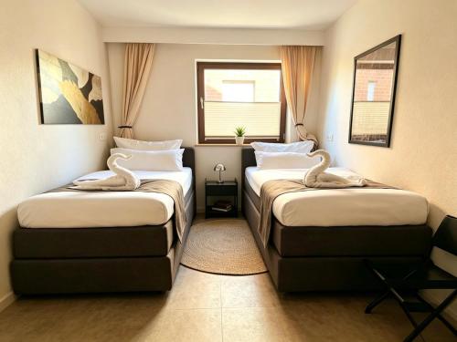 a hotel room with two beds and a window at Suite nähe Klinik, Theme, Parkplatz in Bad Lippspringe