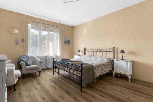 a bedroom with a bed and a chair and a window at La Locanda Del Molino in Fortunago