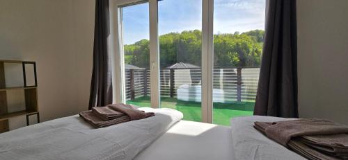 a bedroom with a large window with a view of a yard at Das Haus in Furth an der Triesting