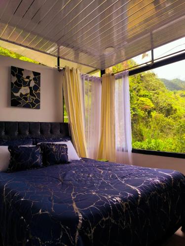 a bedroom with a bed and a large window at Alma Luna Chalet in Vergara