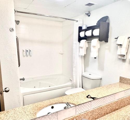 a bathroom with a sink and a toilet and a tub at Country Inn & Suites by Radisson, Dunn I-95 in Dunn