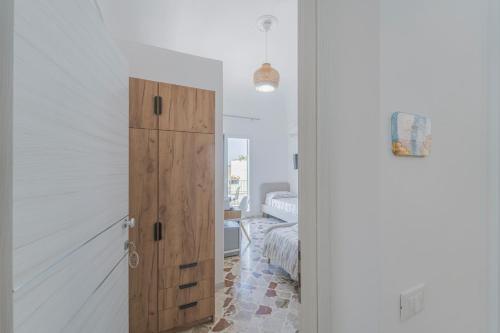 a room with a wooden cabinet and a bedroom at Ponente & Maestro Rooms in Favignana