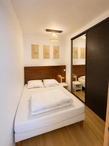 a bedroom with a large white bed and a mirror at Éclat d'Écume - Vue mer - Hypercentre - 31 M2 - Quiberon in Quiberon