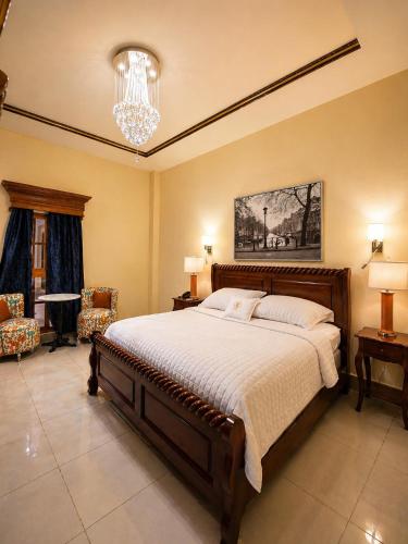 a bedroom with a large bed and a chandelier at GRAN HOTEL VICTORIA in Rivas