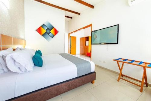 a bedroom with a bed and a flat screen tv at Hotel Optimum in Pereira