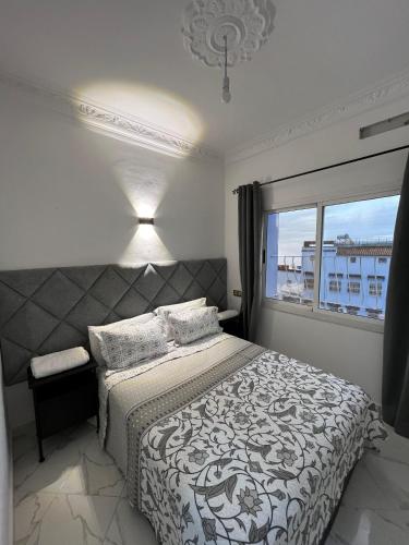 ein Schlafzimmer mit einem großen Bett und einem Fenster in der Unterkunft Ammour Apartment in Chefchaouen