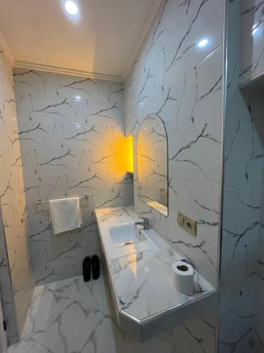 ein Badezimmer mit Waschbecken und Marmorwand in der Unterkunft Ammour Apartment in Chefchaouen