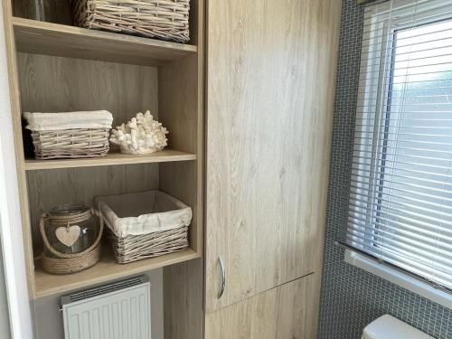 a cupboard with towels and baskets in a bathroom at Modern Seton Sands Caravan - sleeps 6 in Port Seton