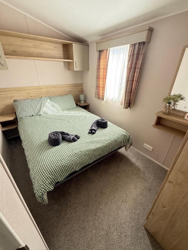 a bedroom with a bed with towels on it at Modern Seton Sands Caravan - sleeps 6 in Port Seton