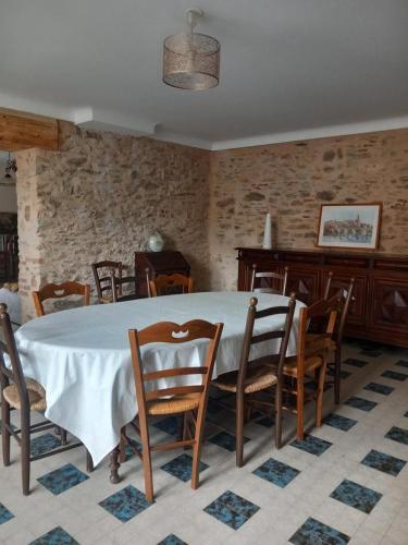 una sala da pranzo con tavolo e sedie bianchi di Trivalou a Fauch