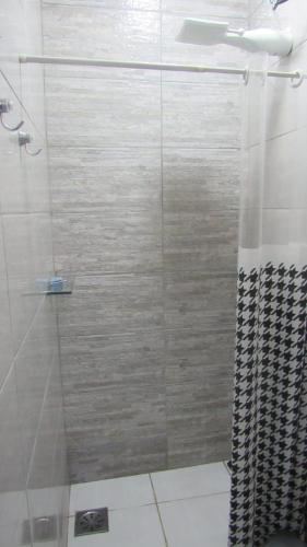 a bathroom with a shower with a glass door at Edícula Recanto das Palmeiras in Uberaba