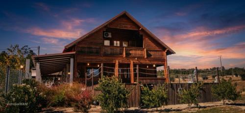 a wooden house with a fence and a sky at Chalé Casa das Estrelas MM in Pinhanços