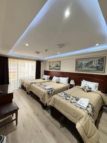 a room with three beds in a room at Hotel Milán in Cuenca