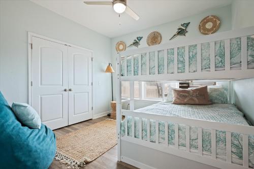 a bedroom with a white bunk bed with blue and white walls at Let's get Beachy! in Bolivar Peninsula