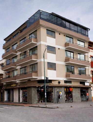 a tall building on the corner of a street at Hotel Milán in Cuenca