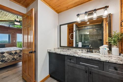 a bathroom with a sink and a mirror at All About Romance by Venture Smoky Mountains in Henderson Springs