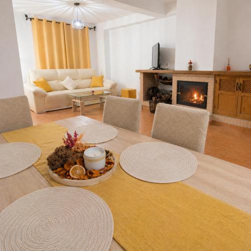 a living room with a table with chairs and a fireplace at Mi Rincón Blanco in Grazalema