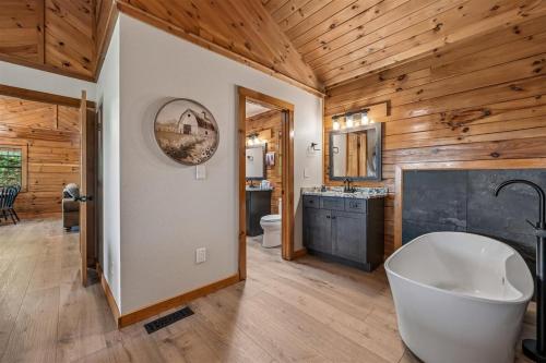 a bathroom with a large tub and wooden walls at A Hen House by Venture Smoky Mountains in Pigeon Forge