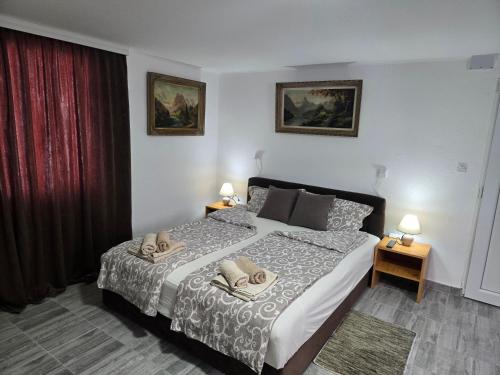 a bedroom with a bed with two pillows on it at Studio Villa Ruža in Golubac