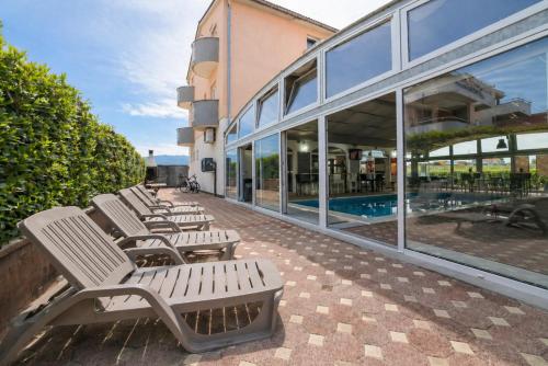 a row of benches sitting in front of a building at Apartments Peris Resort in Novalja