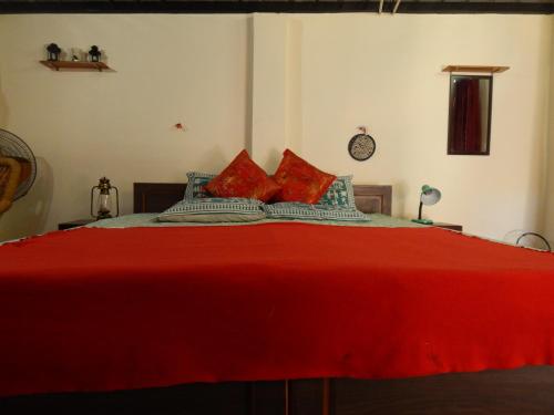 a bedroom with a red bed with red pillows at Dhanaulti Camp Homes Retreat in Dhanaulti