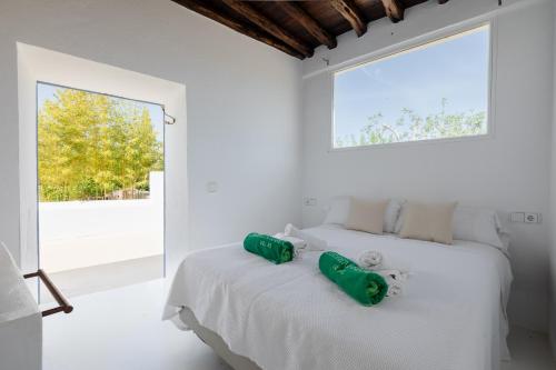 a white bedroom with a bed with green pillows on it at New! Villa Plana Menut in Santa Gertrudis de Fruitera