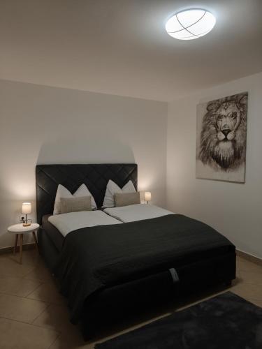 a bedroom with a large bed with a lion picture on the wall at Apartman Ćosić in Kruševica