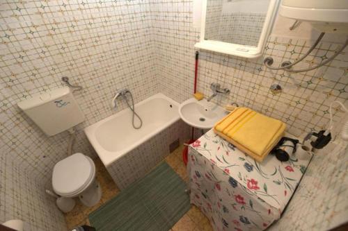 a bathroom with a sink and a tub and a toilet at Maja Apartman in Igalo