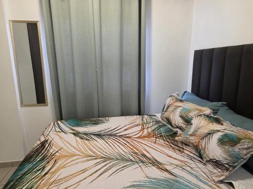 a bed with a comforter and two pillows at One Bedroom Apartment B in Kempton Park