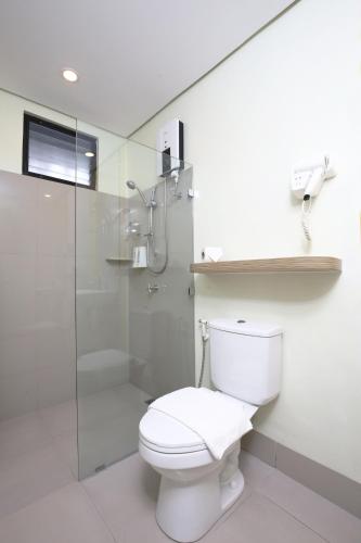 a white bathroom with a toilet and a shower at Hop Inn Hotel Ermita Manila in Manila