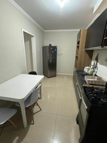 a kitchen with a refrigerator and a table in it at Aparth ijui hotel in Ijuí