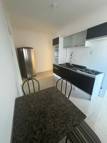 a kitchen with a table and chairs and a refrigerator at Aparth ijui hotel in Ijuí