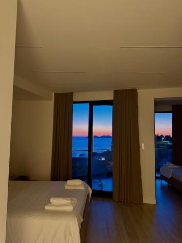 a bedroom with a bed with a view of the ocean at Hotel Gramozi in Kaninë