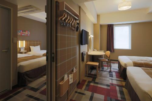a hotel room with two beds and a bathroom at Hotel Monte Hermana Kobe Amalie in Kobe