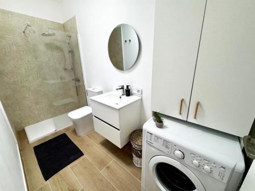 a bathroom with a sink and a washing machine at Silent Paradise Drago Complex in Costa Del Silencio