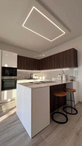 a kitchen with a white island with two stools at Casa Amarèa in Fano