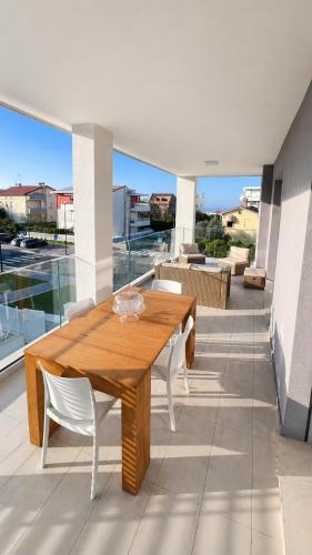 a wooden table and white chairs on a balcony at Casa Amarèa in Fano