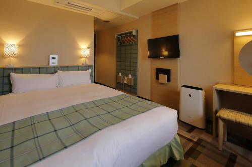 a hotel room with a bed and a television at Hotel Monte Hermana Kobe Amalie in Kobe