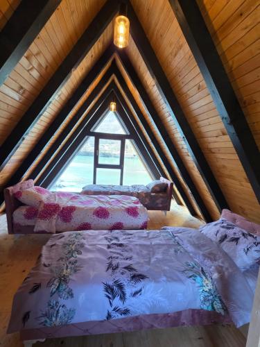 two beds in a attic room with a window at Villa Sanja I Villa Aleksa in Bratunac