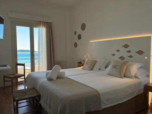 two beds in a bedroom with a view of the ocean at Carabela in Paguera