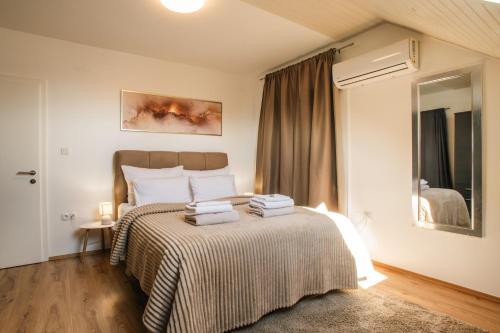 a bedroom with a bed with towels on it at UrbanApartment5 in Čakovec