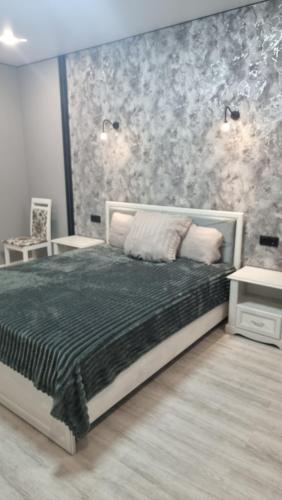 a bedroom with a bed with a black comforter at Luxury in Kokshetau